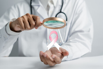 Doctor holding virtual pink ribbon cancer, Breast cancer awareness and health care medical check-up...