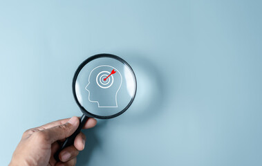 Magnifying glass focus to human brain and target objective icon inside for plan, thinking business strategy development leadership and customer target group concept.