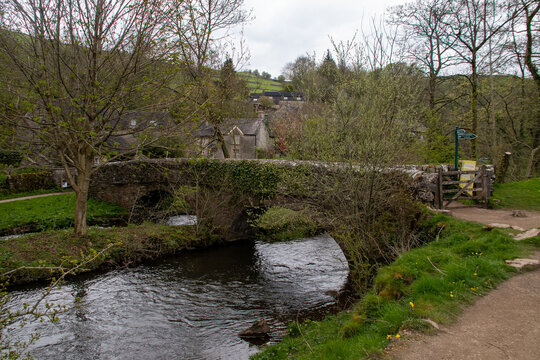 Traditional medieval stone bridge crossing the River Dove in Peak District village Milldale, UK