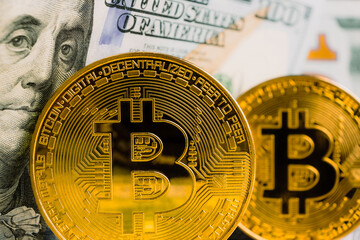 Close-up of a gold Bitcoin and a hundred dollar bill. Cryptocurrency. Business and Trading concept. Close-up shot coin.