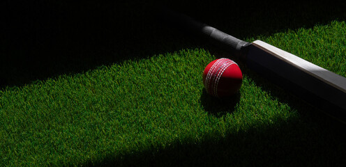 Cricket bat and red ball with natural lighting on green grass. Horizontal sport theme poster, greeting cards, headers, website and app