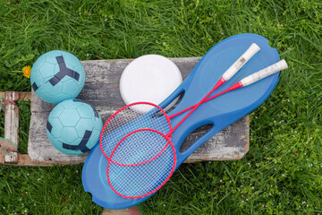 A set of sports items for entertainment. Footballs, badminton rackets, frisbees. Items for sports.