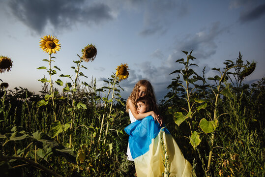 Ukrainian children hug under the yellow-blue flag. Children of war. The concept of support and assistance to Ukraine. The Future of Ukraine. Stop the war.