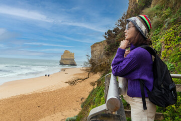 Middle-aged Asian woman backpacking backpacker excitedly arrives at her destination Port Campbell...