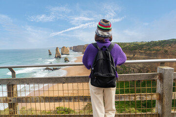 Middle-aged Asian woman backpacking backpacker excitedly arrives at her destination Port Campbell...