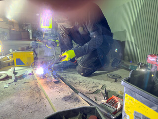 Welding with argon or electrode, using a welding machine. Sparks and flashes fly.