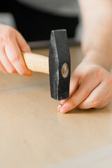 Close up of hammering a nail into wooden board