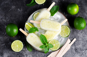 Refreshing Lime Popsicles, Brazilian Lemonade Ice Lolly with Fresh Lime and Mint on Dark Background