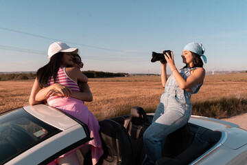 During the summer trip, the young woman wearing a blue headscarf takes a photo with her SLR camera...