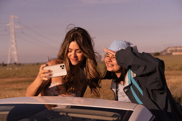 The two friends review the photos they have taken, they are traveling through the countryside in a...