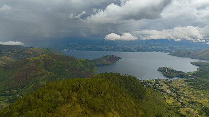 Aerial drone of Lake Toba and Samosir island. among the mountains with tropical vegetation. Sumatra, Indonesia.