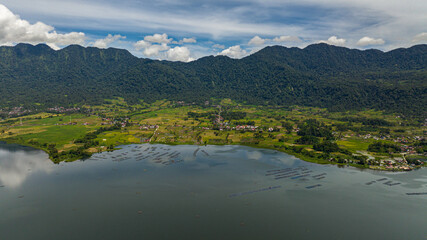 The shore of the lake Maninjau with farmland and a village. Sumatra, Indonesia.