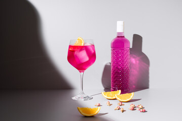 Refrescante gin tónica rosa decorado con naranja 