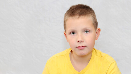 Fototapeta premium Portrait of a teenage boy in a yellow T-shirt.