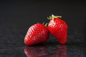 Strawberry. Red ripe strawberries on a black marble background. Selective focus
