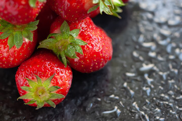 Ripe strawberries. Juicy ripe strawberries with drops of water on a wet dark background. Red berries. Copy space. Close-up. Selective focus