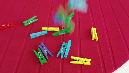 colorful pegs falling on red ground