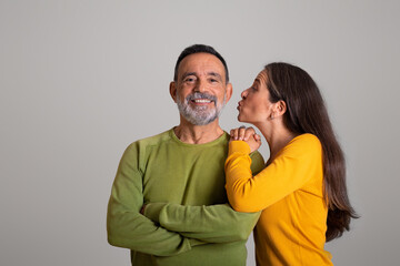 Naklejka premium Cheerful old european wife kisses her husband on cheek, enjoy date