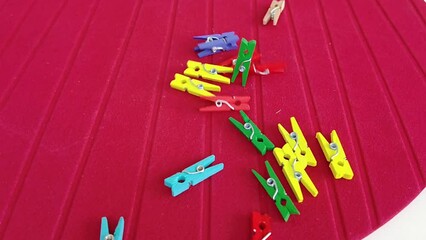 colorful pegs falling on red ground