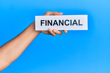 Hand of caucasian man holding paper with financial word over isolated blue background