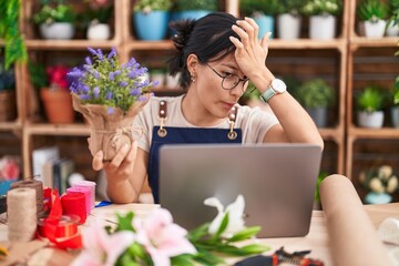 Young hispanic woman working at florist shop doing video call pointing fingers to camera with happy and funny face. good energy and vibes.