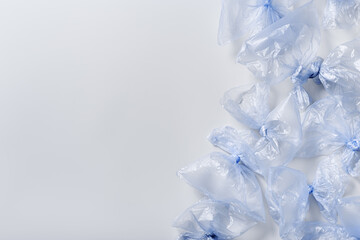 Colored used plastic bags flat lay, polyethylene packages on light background. Sustainable...