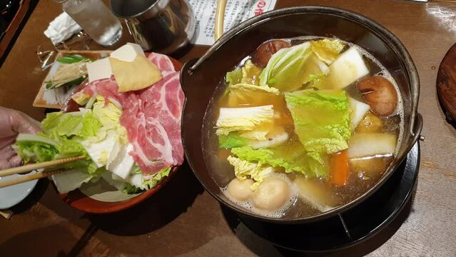 Staff arranging chanko nabe Sumo stew hot pot. Weight gain traditional food for Japanese wrestle