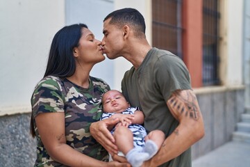 Hispanic family hugging each other and kissing at street