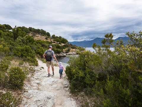 Dad doing hiking with his little girl on the Corsican coastline. France 2023