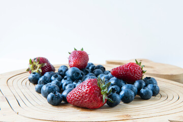 Strawberries and blueberries on wooden background