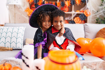 Adorable african american boy and girl wearing halloween costume hugging each other at home © Krakenimages.com