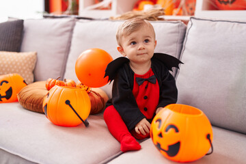 Adorable caucasian boy wearing bat costume having halloween party at home