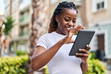 African american woman smiling confident using touchpad at street