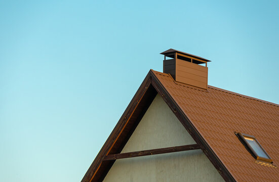 Sharp house roof with window and clear blue sky
