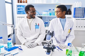 Man and woman scientists smiling confident at laboratory