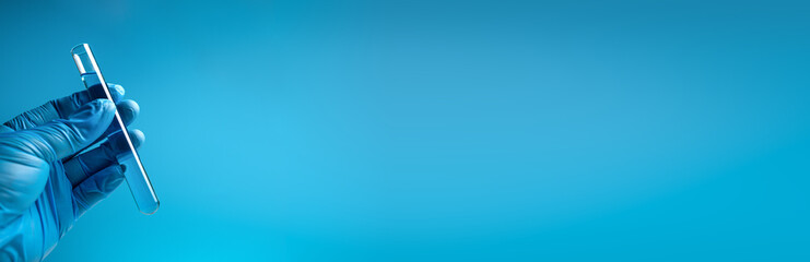 Hand in blue gloves holding laboratory test glass tube. Long banner.