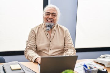 Middle age grey-haired man business worker using laptop working at office