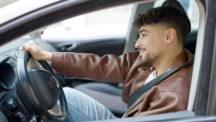 Fototapeta na wymiar Young arab man smiling confident driving car at street