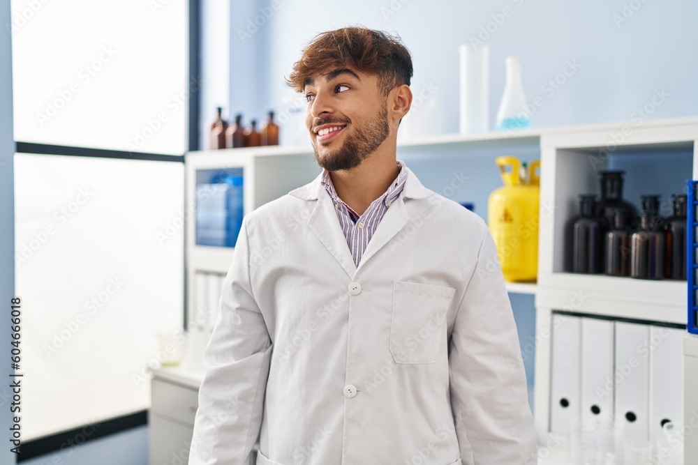 Poster arab man with beard working at scientist laboratory looking to side, relax profile pose with natural