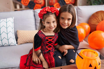 Adorable boy and girl wearing halloween costume hugging each other at home