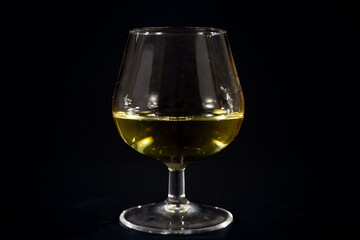 cognac glass containing cognac brandy on a black background in a studio, isolated. Cognac is a famous french hard liquor, a distillate of wine.