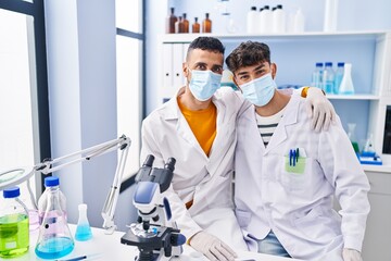 Two man scientists wearing medical mask at laboratory