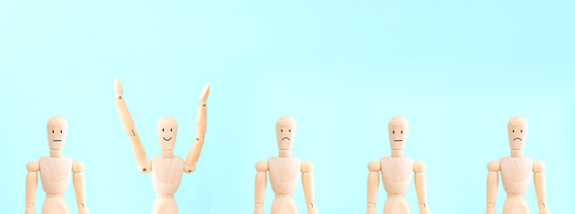 A wooden figure with a smiling face raises its hands