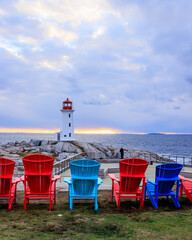 Deck Chairs facing a lighthouse on rocky shore