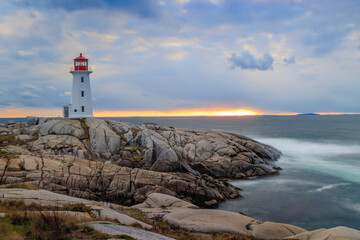 Lighthouse with smooth water beside rocks