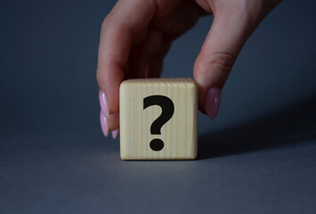 Question mark symbol. Concept words question mark on wooden cube. Businessman hand. Beautiful grey background. Business and question mark. Copy space.