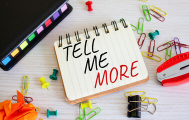 Tell me more symbol. Concept words Tell me more on wooden notebook. Beautiful wooden background. Business and Tell me more concept. Copy space.