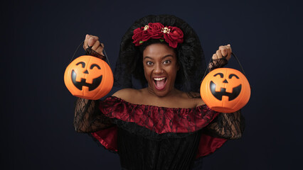 African american woman wearing katrina costume holding halloween pumpkin baskets over isolated...