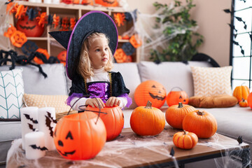 Adorable blonde girl wearing witch costume having halloween party at home