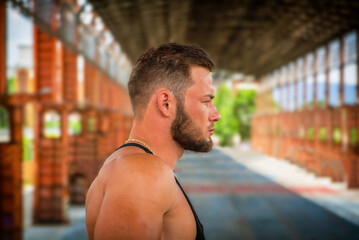 Muscular attractive athletic man in city park